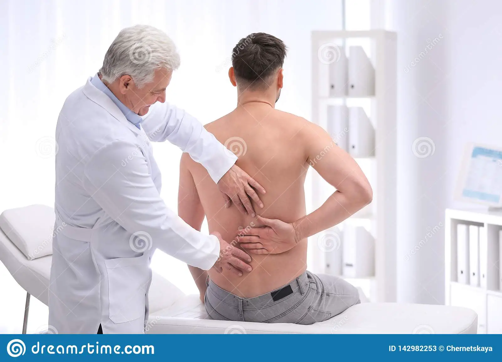 Chiropractor Examining Patient With Back Pain Stock Image