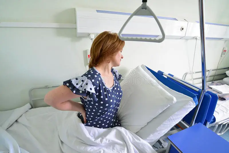 Female Patient With Back Pain On Bed In Hospital Ward Stock Image ...